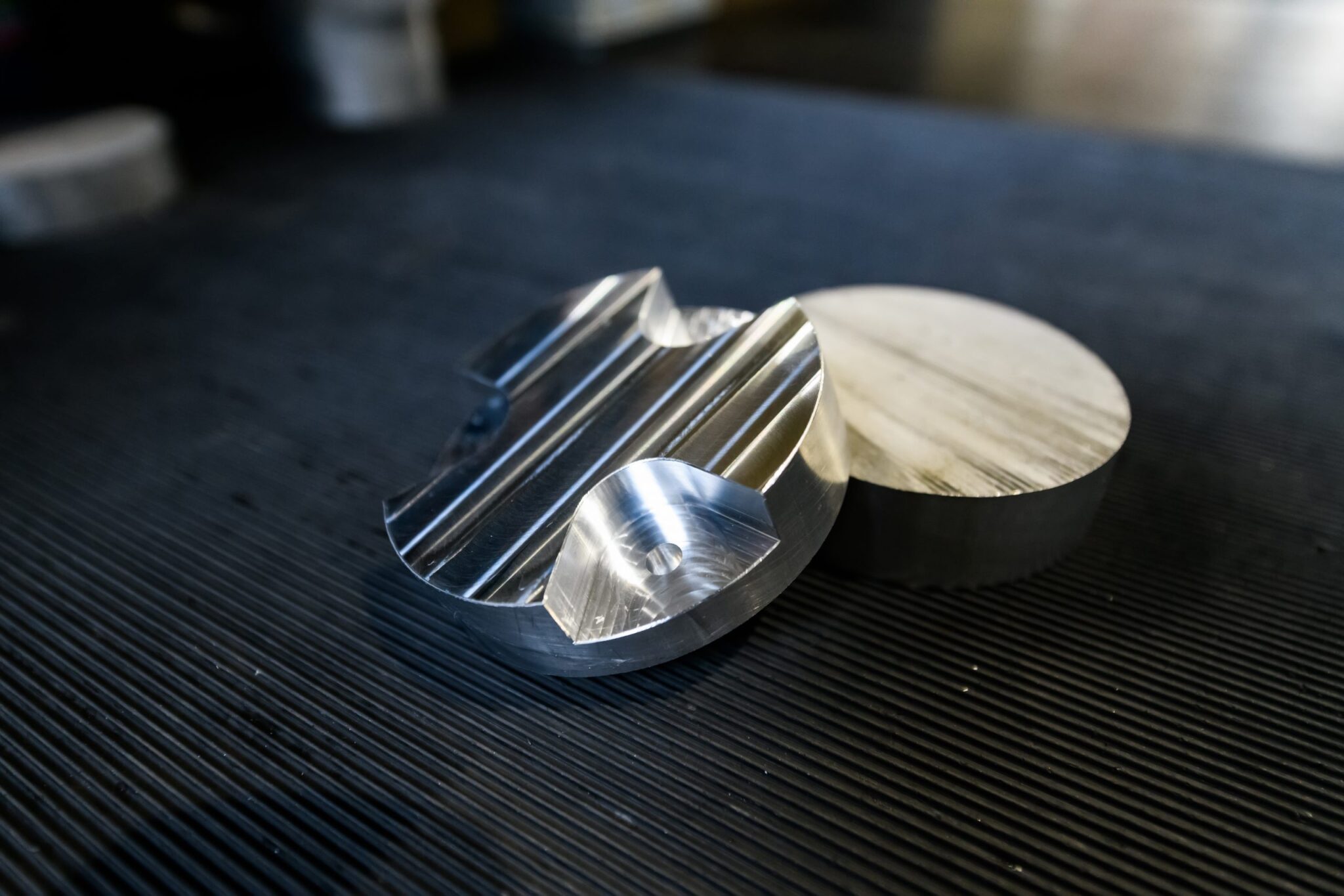 CNC-gefertigte Aluminiumbauteile und Metallstifte auf technischer Oberfläche für Industrieanwendungen