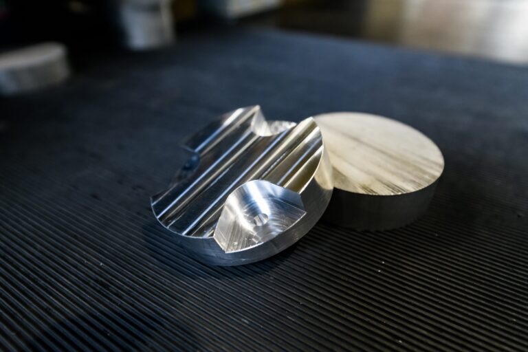 CNC-gefertigte Aluminiumbauteile und Metallstifte auf technischer Oberfläche für Industrieanwendungen