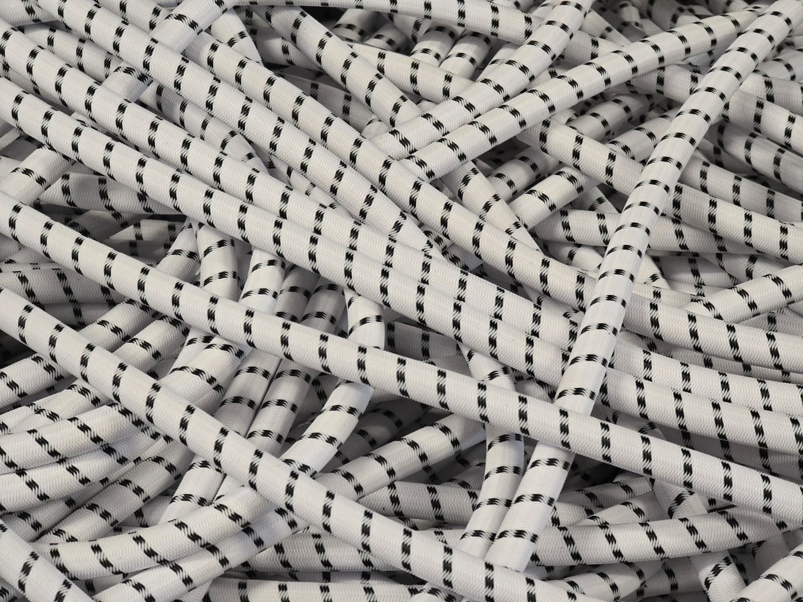 Technische Gummiseile in Weiß mit kontrastierender schwarzer Umflechtung – hochwertiges Expanderseil für industrielle Anwendungen, Deuser Systems.